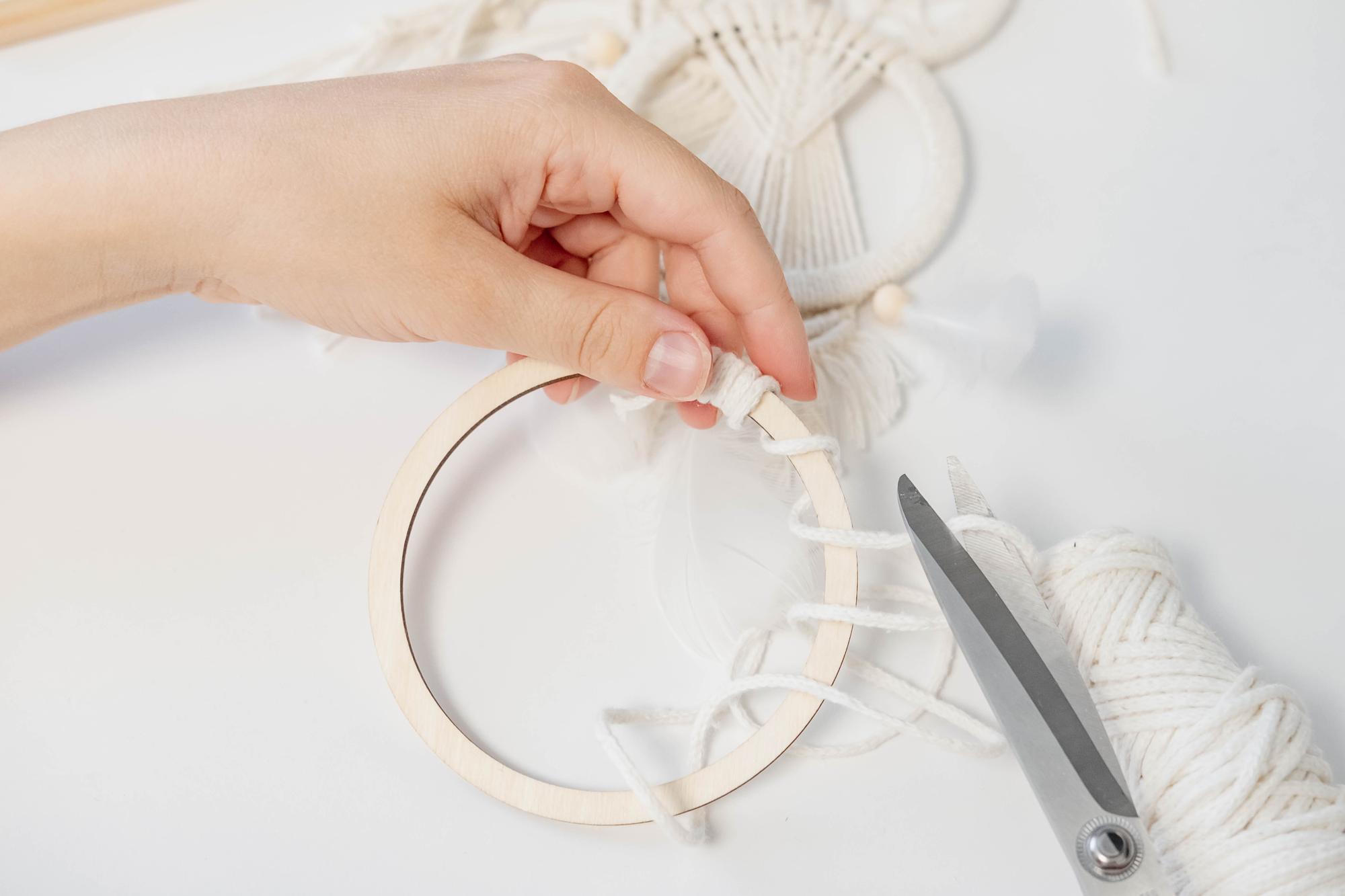 Hand holding an embroidered hoop with geometric design